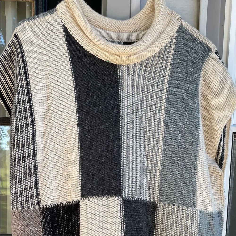 Beautiful color block sweater. Sleeveless, long poncho w/fringe at bottom.